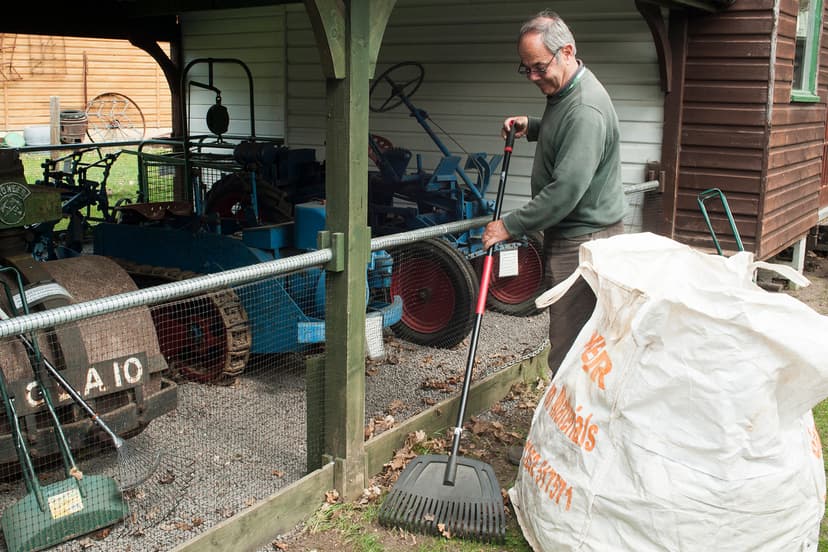 A volunteer raking leaves at the Rural Life Living Museum