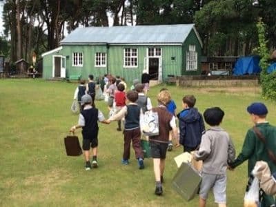 Picture of children walking into the school house.