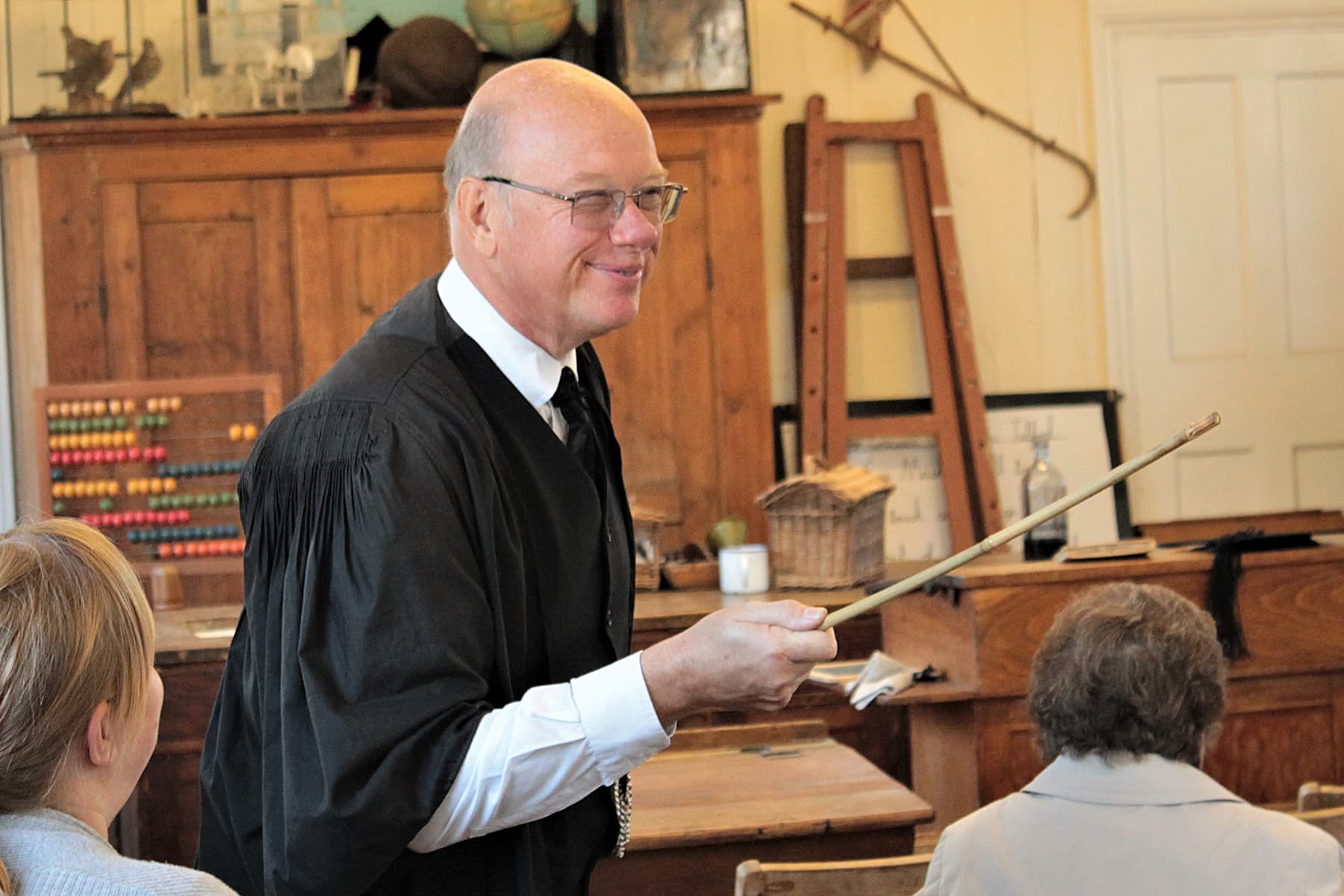 A picture of a victorian teacher, teaching a class, with a child with a dunce cap in the front row.