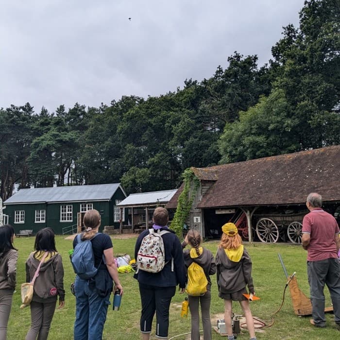 A photo of youth groups looking at the building in the Rural Life Living Museum.